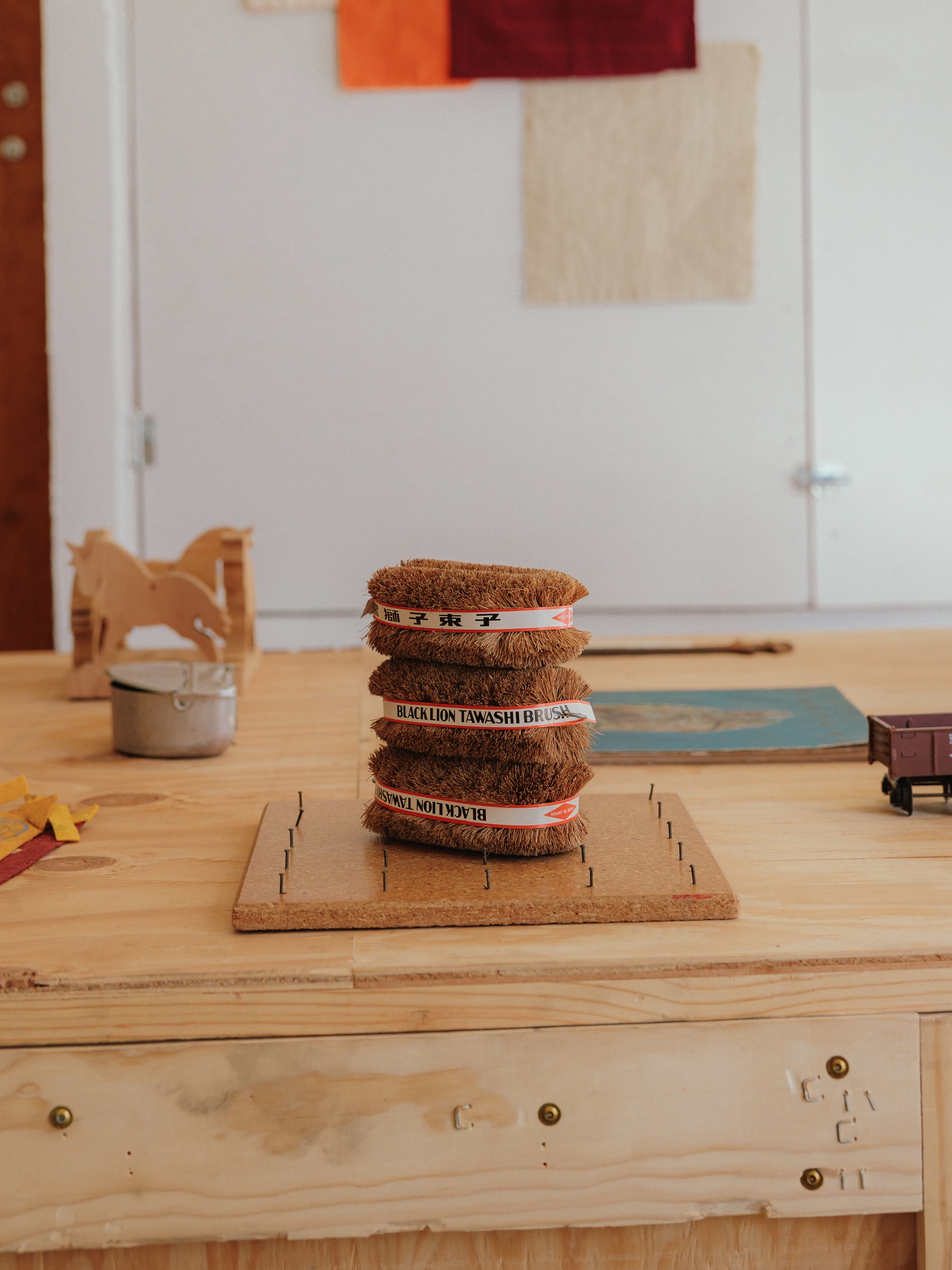 Tawashi scrubbers and collected wooden objects on a worktable
