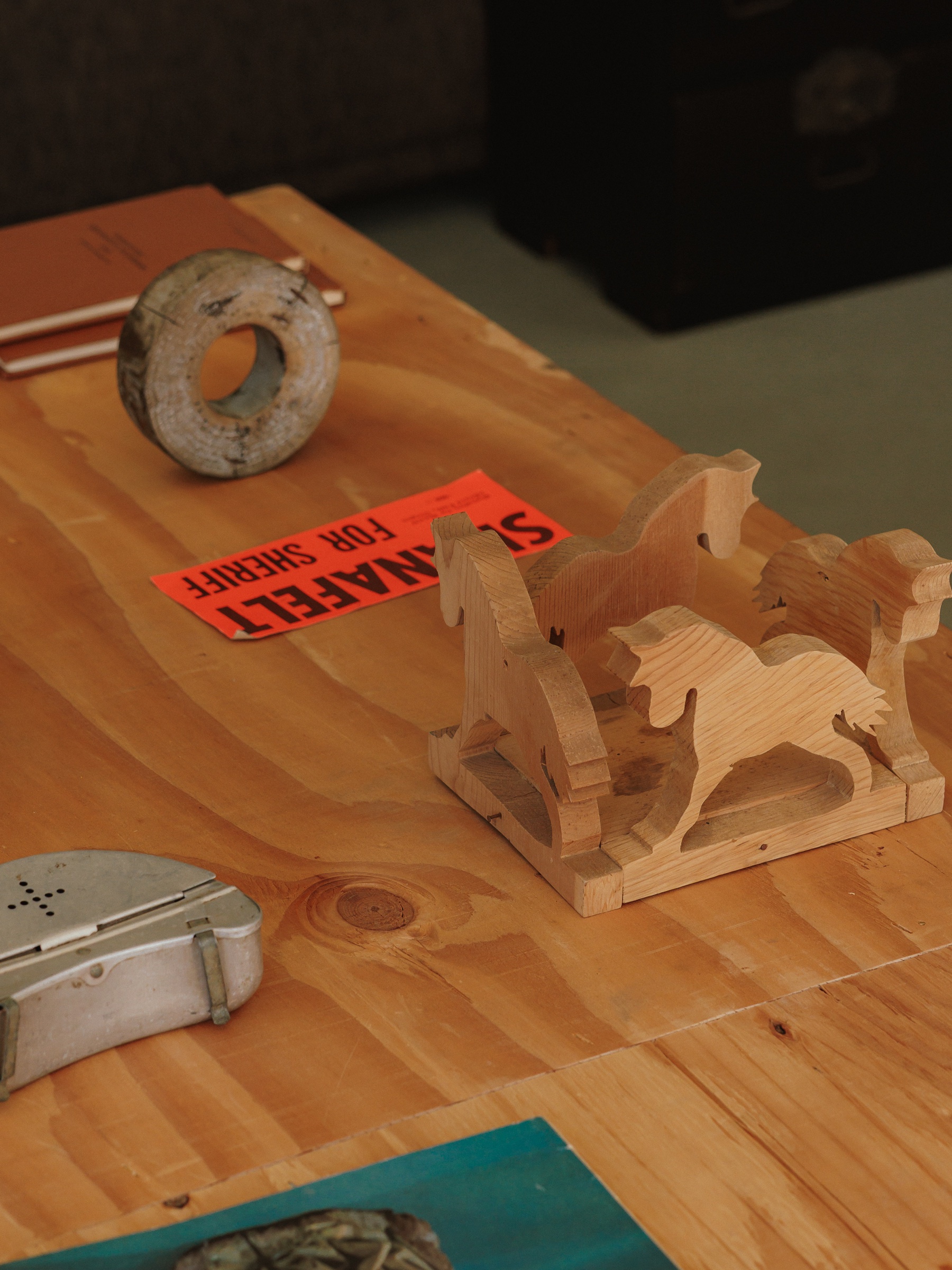 Handmade wooden horses and collected objects on a worktable