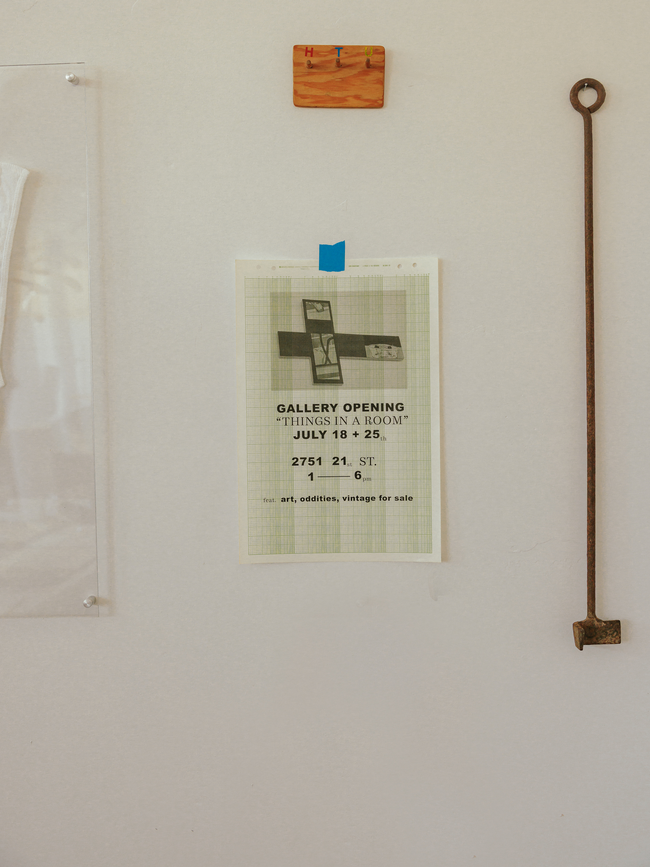 A Things in a Room gallery poster displayed among objects on a studio wall