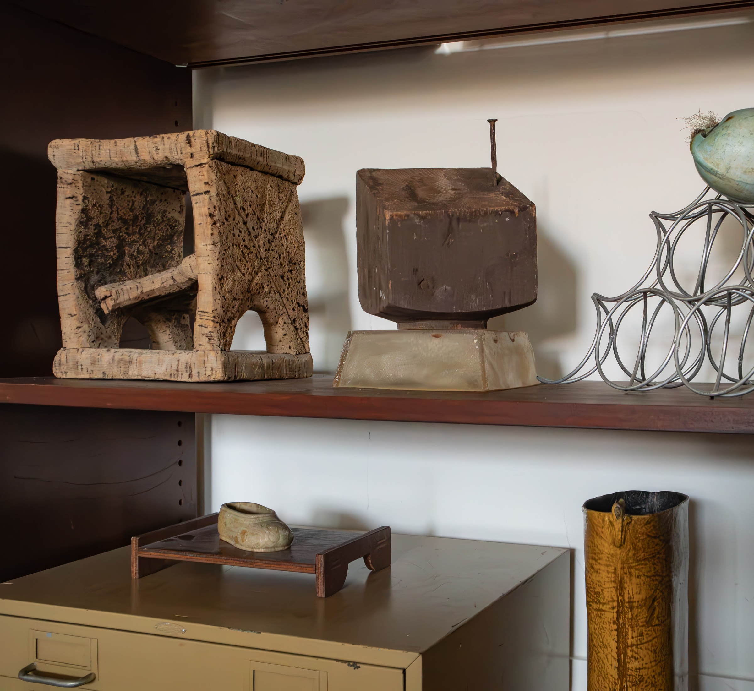 Collected sculptural objects arranged on open shelving