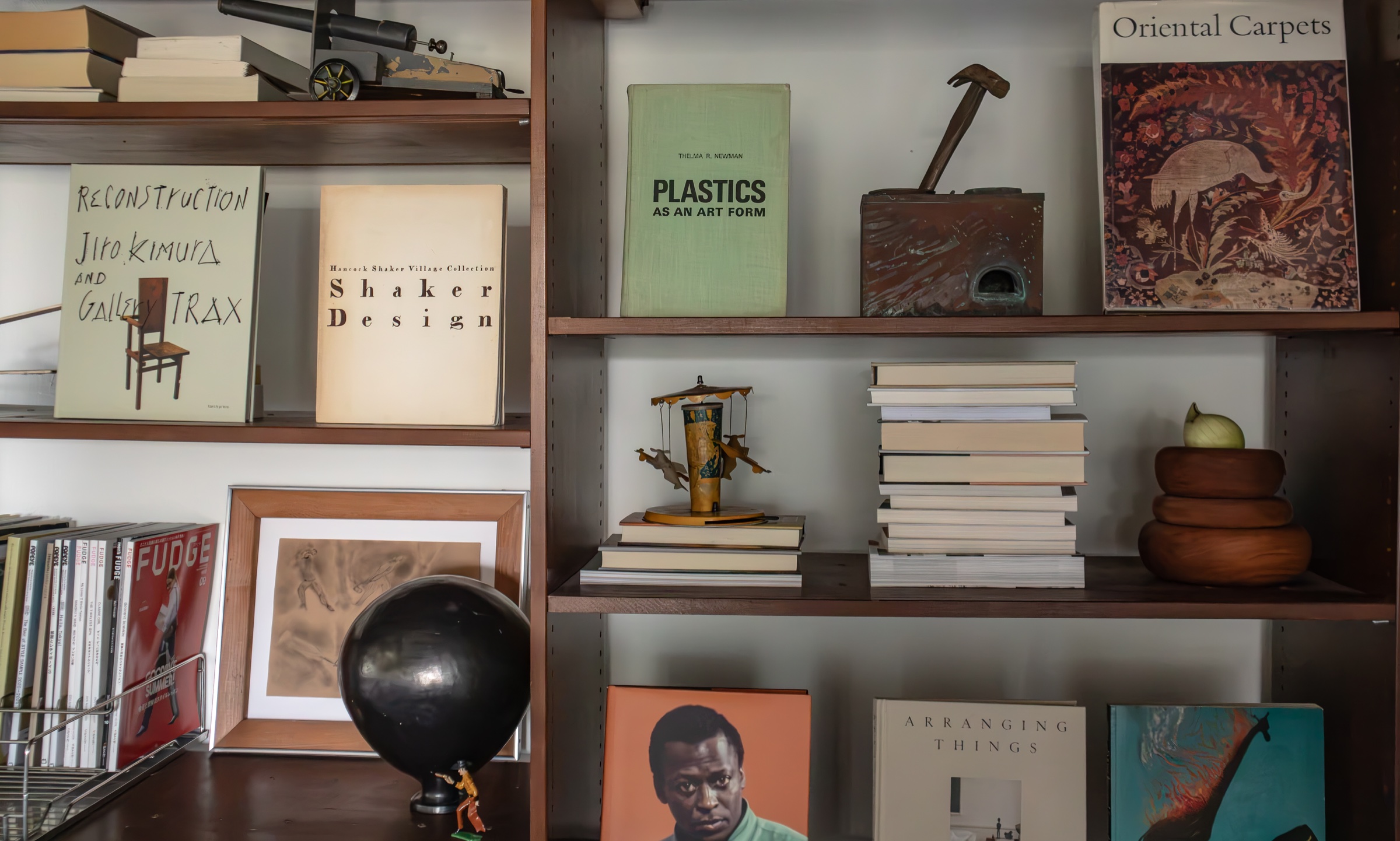 Books, artwork, and collected objects on open shelving