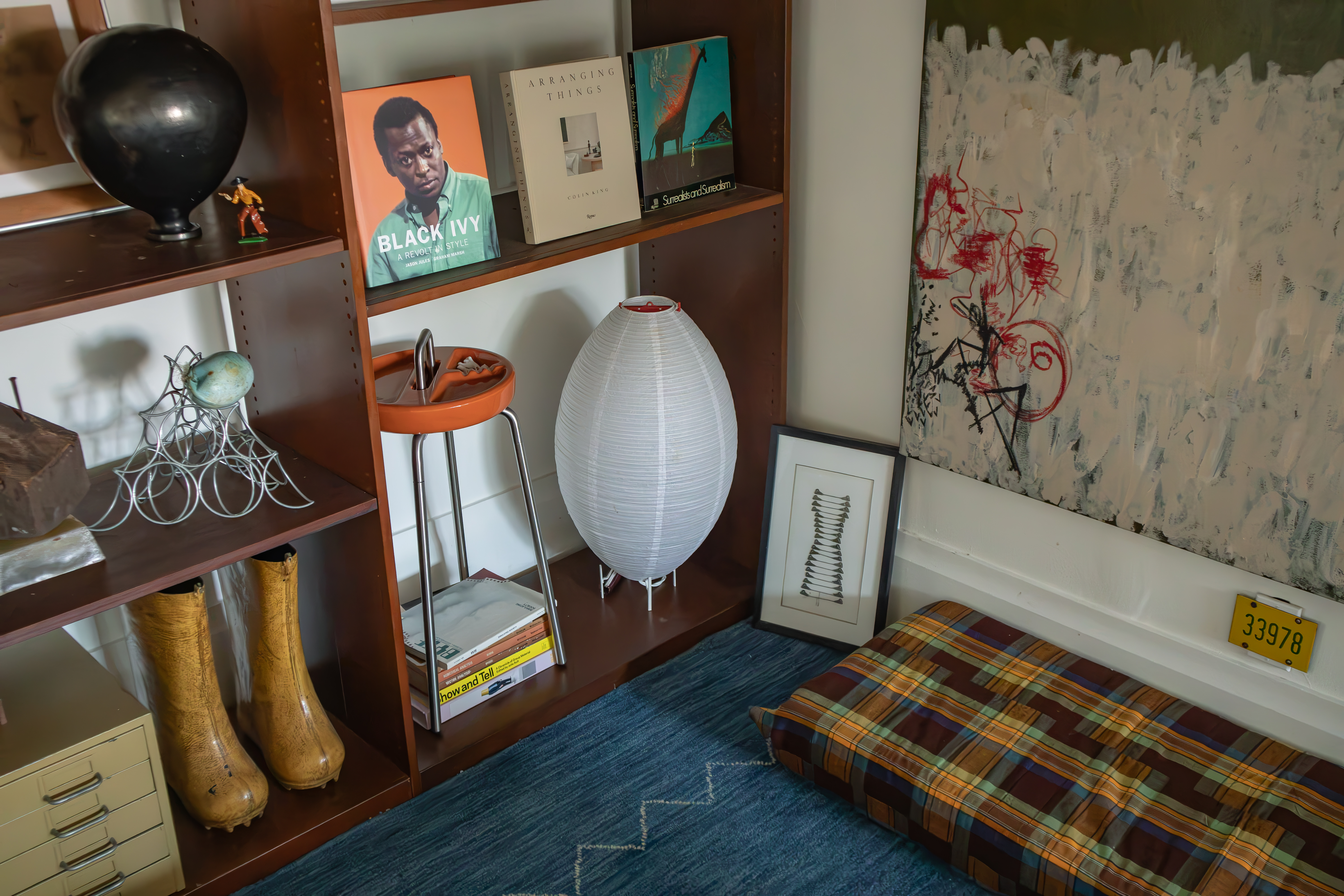 A paper lantern, books, artwork, and collected objects in a living room