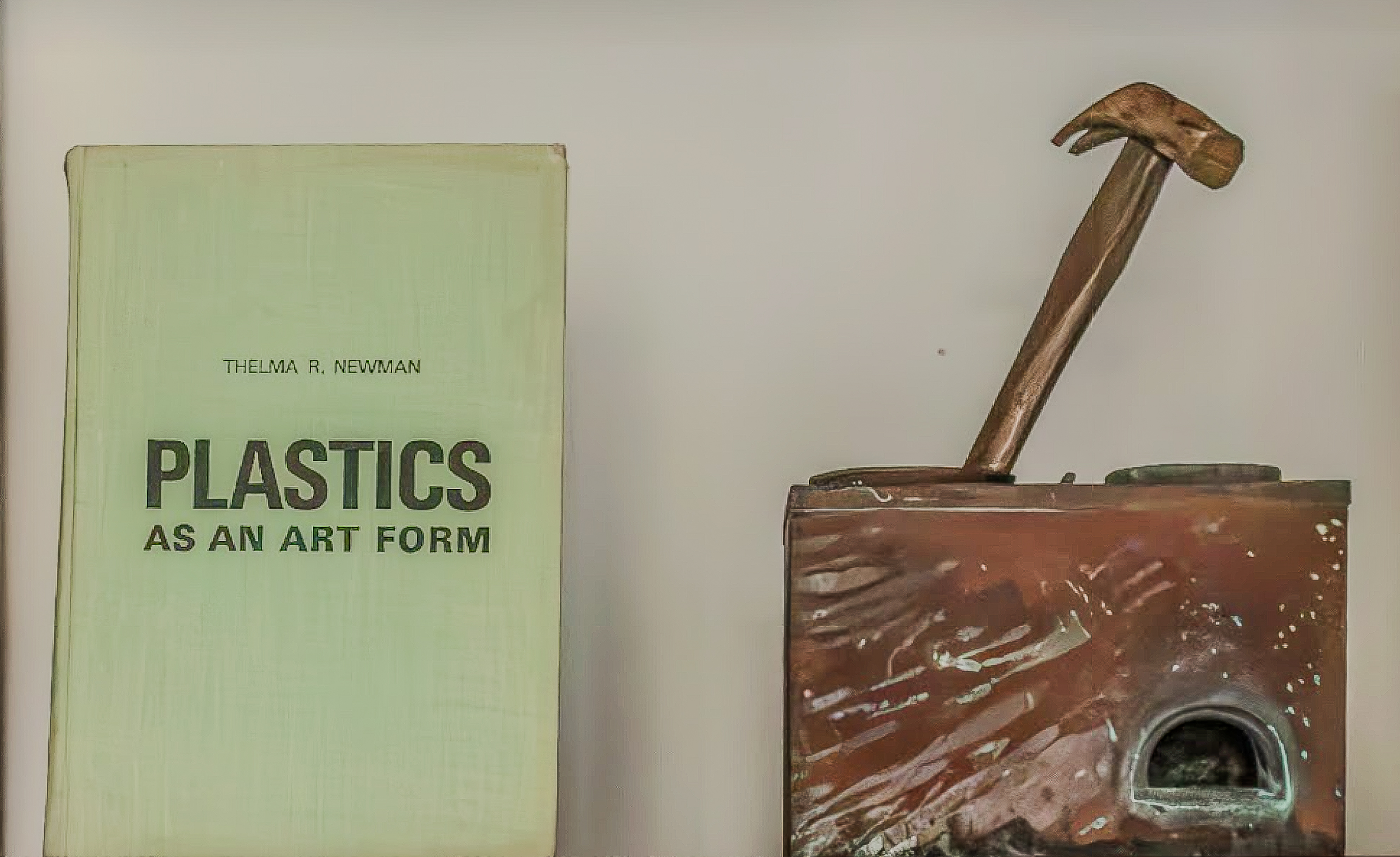 A book about plastics beside a handmade sculptural object